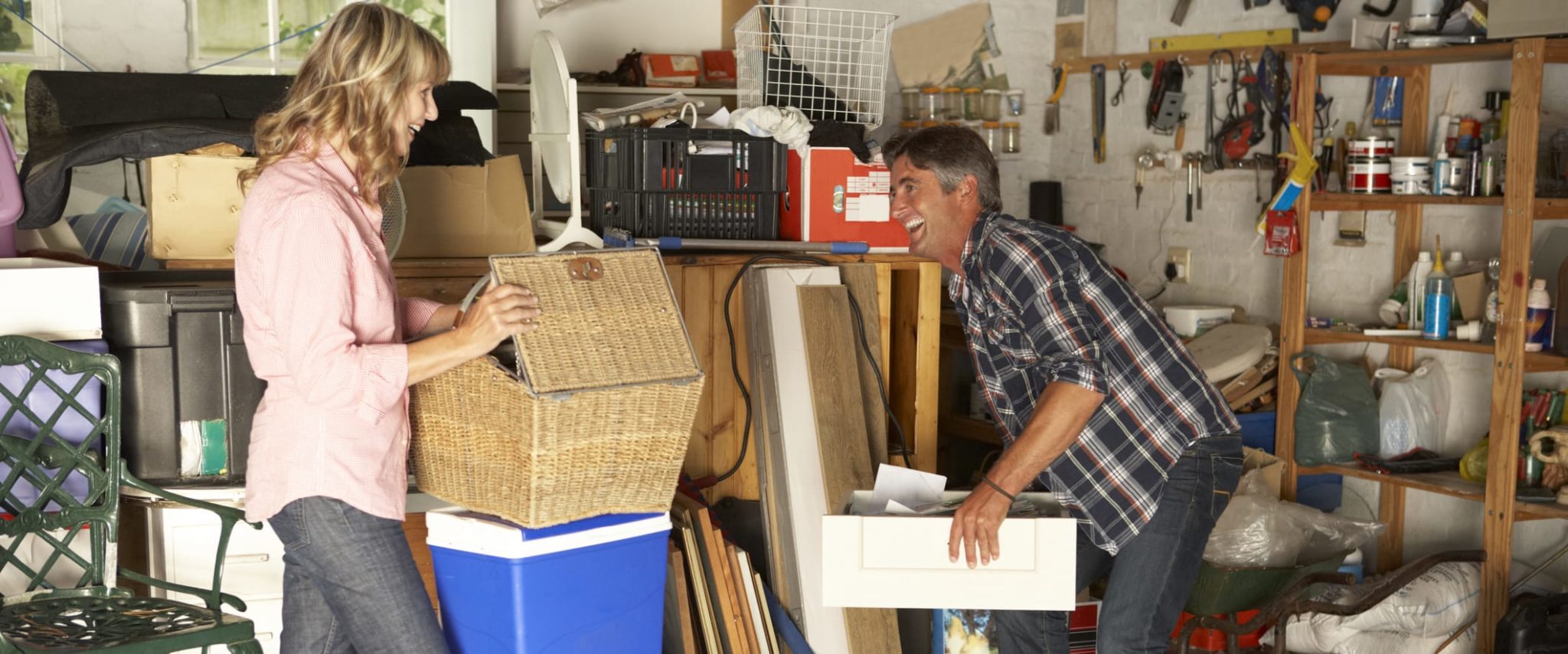 Happy man and woman storing items in garage